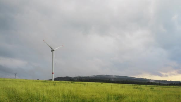 Osamělý elektrický větrný mlýn v terénu a deštivé obloze — Stock video