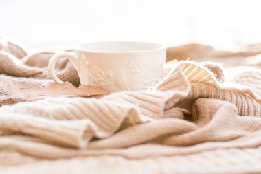 Sıcak örme kazak, sıcak çay ve kırmızı termos bardak