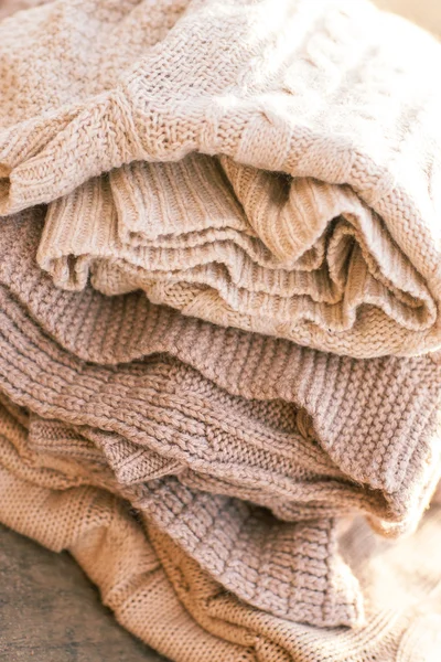 Pilha de roupas de inverno de malha em fundo de madeira, suéteres, k — Fotografia de Stock