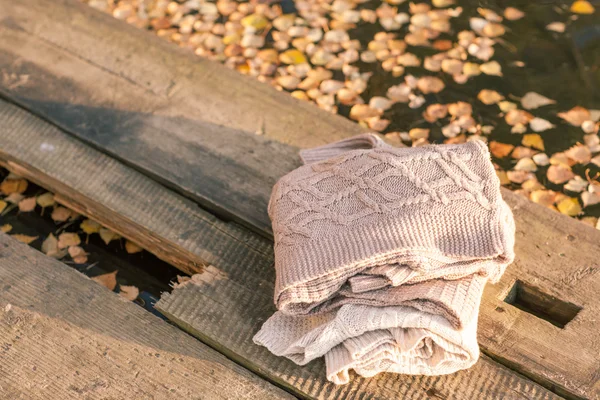 Stos z dzianiny zimowych ubrań na podłoże drewniane, swetry, k — Zdjęcie stockowe