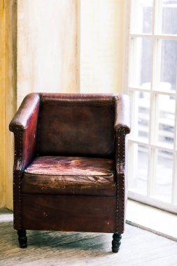 Antika arka plan ve ahşap zemin üzerinde eski deri sandalye