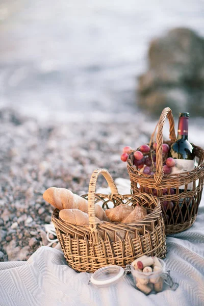 Fondo de picnic con cesta, vino y frutas junto al océano — Foto de Stock