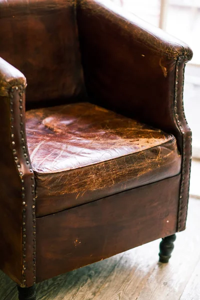 Silla de cuero vieja sobre fondo vintage y suelo de madera —  Fotos de Stock