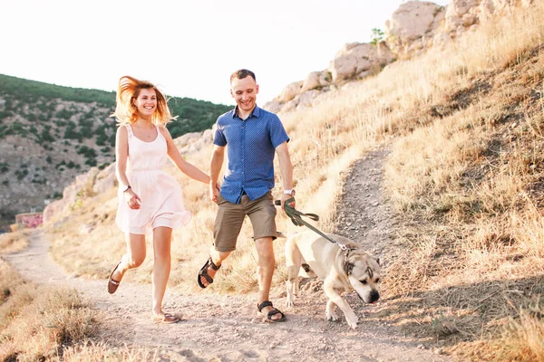 Par killar leker med sin hund på berget nära havet — Stockfoto