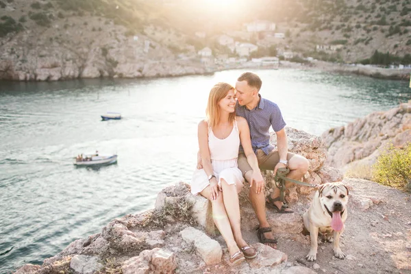 Couple of guys playing with their dog on the mountain near ocean — Stock Photo, Image