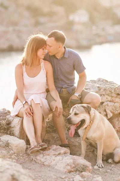 Paar Jungs spielen mit ihrem Hund auf dem Berg in der Nähe des Ozeans — Stockfoto