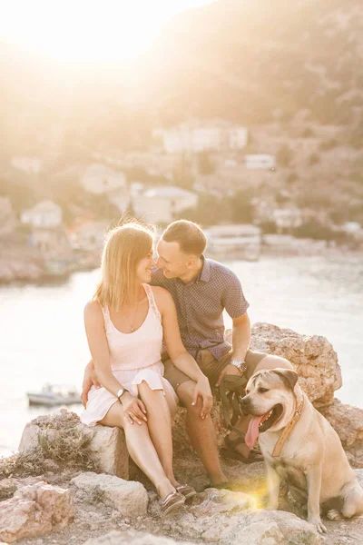 Un par de tíos jugando con su perro en la montaña cerca del océano —  Fotos de Stock