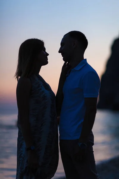 Silhouet van een koppel op het strand bij zonsondergang — Stockfoto