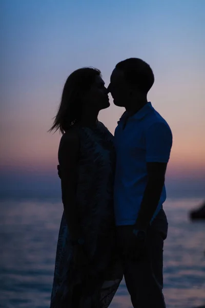 日落时一对夫妇在海滩上的轮廓 — 图库照片