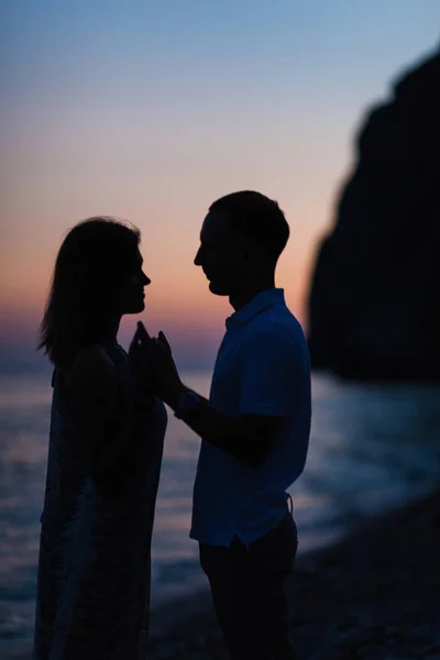 Silhueta de um casal na praia ao pôr do sol — Fotografia de Stock