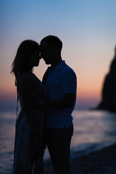 Silhouet van een koppel op het strand bij zonsondergang — Stockfoto