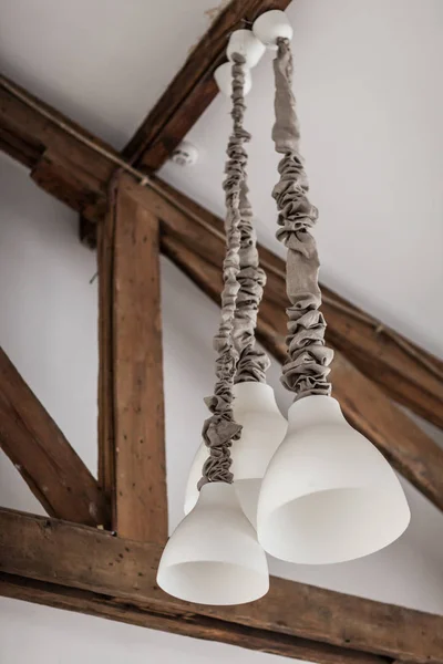 Белая стена с деревянными балками и потолочными лампами — стоковое фото