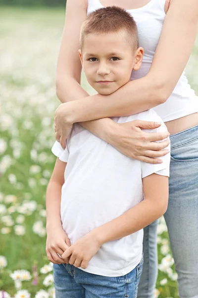 Mutter amüsiert sich mit Sohn im Blütenfeld der Kamille — Stockfoto