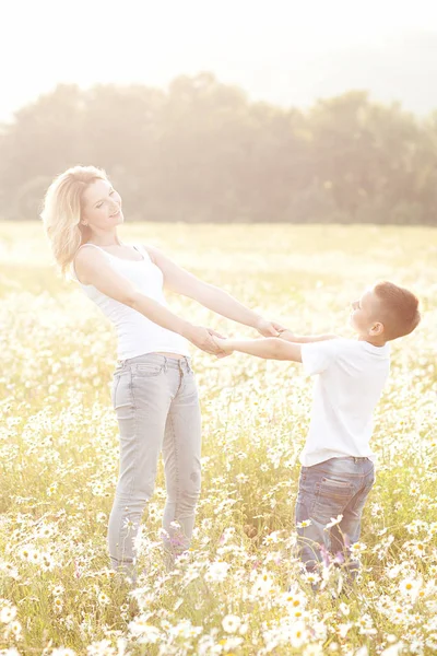 Madre divirtiéndose con su hijo en el campo de flores de manzanilla —  Fotos de Stock