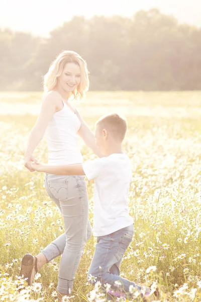 Madre divirtiéndose con su hijo en el campo de flores de manzanilla —  Fotos de Stock