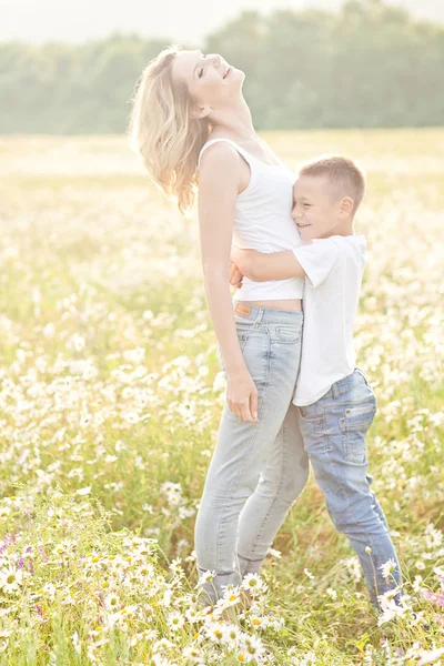 Madre divirtiéndose con su hijo en el campo de flores de manzanilla —  Fotos de Stock