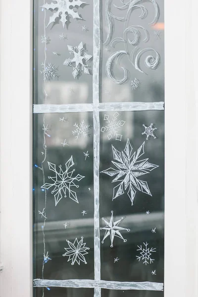 Motifs blancs peints sur verre de la fenêtre du magasin. Décoration f — Photo