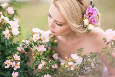 Onun hairst çiçeklerle beyaz elbiseli güzel sarışın gelin