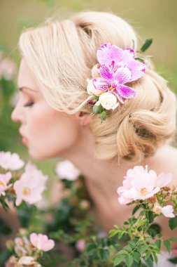 Onun hairst çiçeklerle beyaz elbiseli güzel sarışın gelin