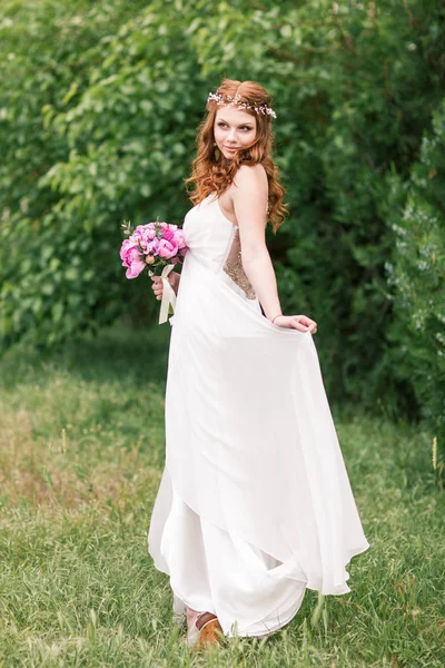 Mooie bruid in witte jurk in de tuin — Stockfoto