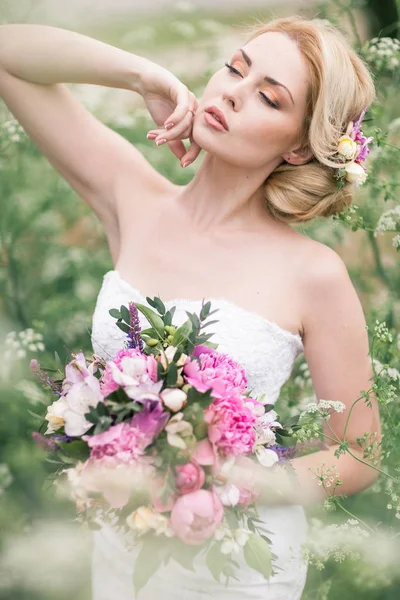 Vackra bruden i vit klänning i trädgården — Stockfoto