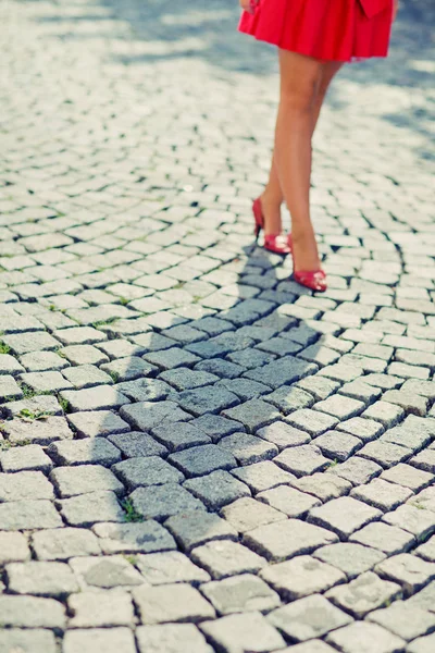 Piernas de mujer en zapatos de tacón rojo y vestido corto al aire libre —  Fotos de Stock