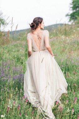 Bir buket çiçek ve yeşil ile güzel bir elbise içinde gelin