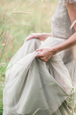 Bir buket çiçek ve yeşil ile güzel bir elbise içinde gelin