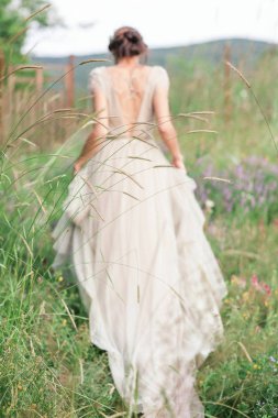 Bir buket çiçek ve yeşil ile güzel bir elbise içinde gelin