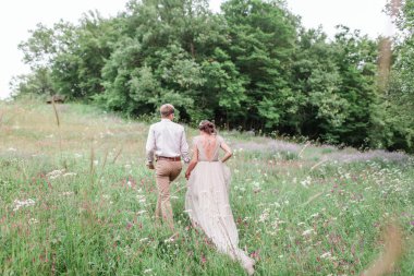 iki sonra düğün kıyafetleri ile bir buket çiçek ve yeşillik 