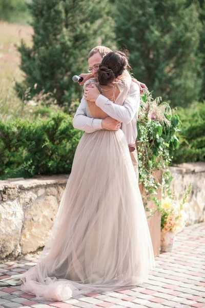 Fille dans une robe de mariée verte et homme barbu en costume et standi — Photo