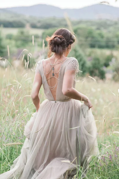 Noiva em um lindo vestido com um buquê de flores e mais verde — Fotografia de Stock