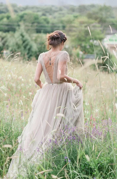 Mariée dans une belle robe avec un bouquet de fleurs et plus vert — Photo