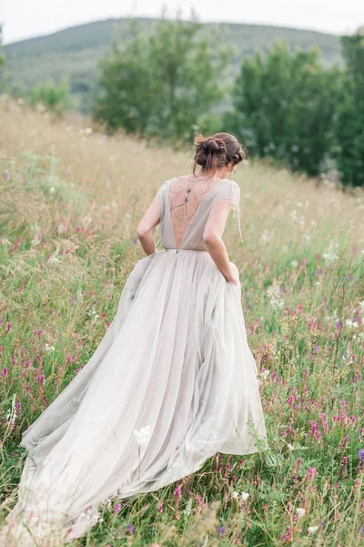 Nevěsta v krásných šatech s kyticí květin a rostlinstvo — Stock fotografie