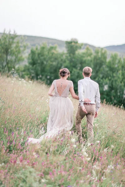 花と緑の花束と結婚式の服装でカップル — ストック写真