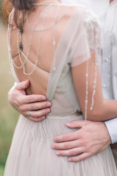 Пара в свадебной одежде с букетом цветов и зелени — стоковое фото
