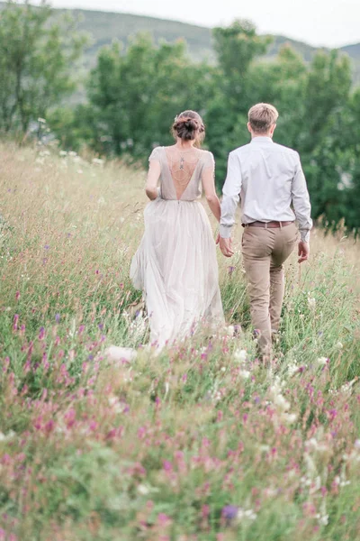 Par i bröllop klädsel med en bukett blommor och grönska — Stockfoto