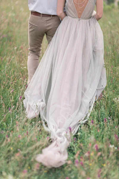 Pareja en traje de novia con un ramo de flores y vegetación —  Fotos de Stock