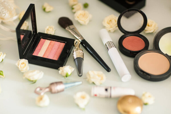 Косметика с тенью для глаз, подкладкой для глаз и порошком на белом столе
 