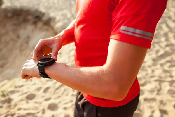 Běžec na horské stezce při pohledu na sportwatch chytré hodinky, chec — Stock fotografie