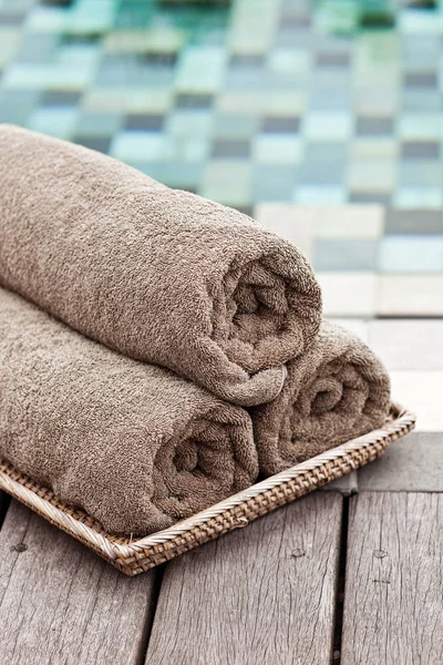 Brown towels in wicker basket at a luxury swimming pool
