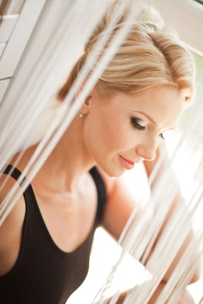 En blond ung kvinna som sitter nära vintage garderob mot wi — Stockfoto