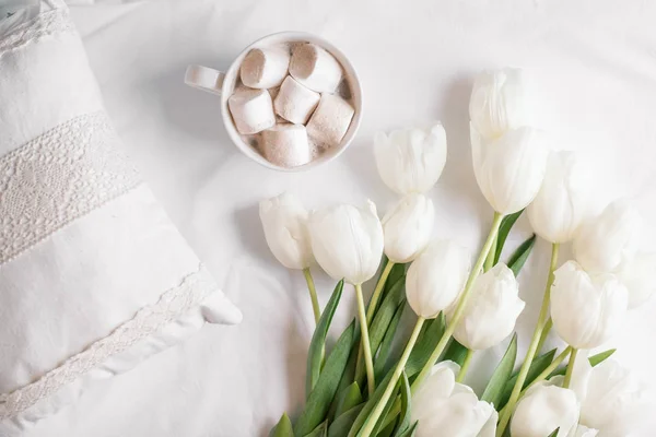 Frühlingsblumen Tulpen mit Kakao und weißen Kissen — Stockfoto