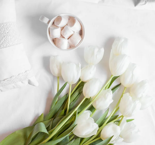 Spring flowers tulips with cacao and white pillows — Stock Photo, Image