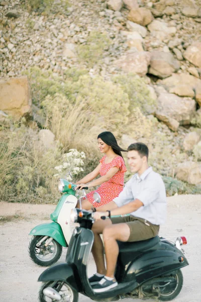 Happy young couple in love on retro motorbike driving togetger and ejoying the trip near the ocean. — Stock Photo, Image