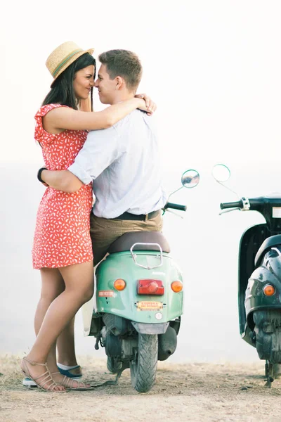 Happy young couple in love on retro motorbike driving togetger and ejoying the trip near the ocean. — Stock Photo, Image