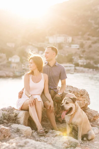 Joven pareja con estilo en el amor paseando jugando al perro al aire libre — Foto de Stock