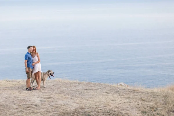 Jovem elegante casal no amor andando jogar cão ao ar livre — Fotografia de Stock