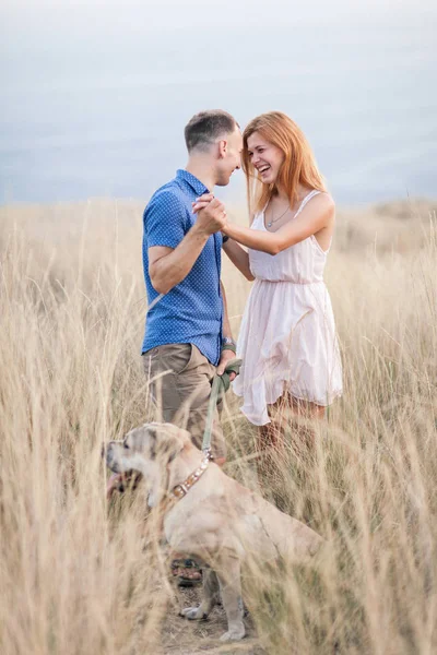 Jong stijlvolle koppel in liefde lopen hond buiten spelen — Stockfoto