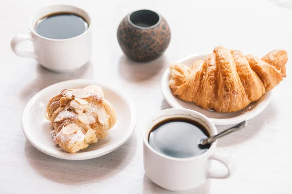 Breakfastat 着杯咖啡，吃牛角面包的白色桌子上 — 图库照片